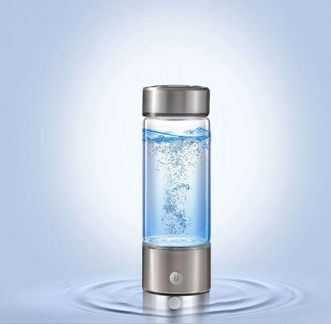 Hydrogen water bottle standing in shallow water with bubbles rising inside the glass