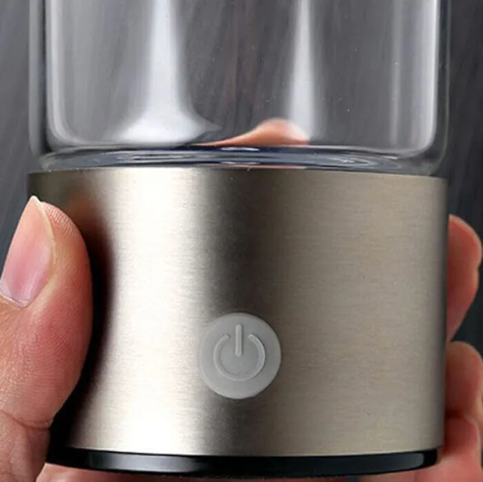 Close-up of a finger pressing the power button on the bottle's steel base